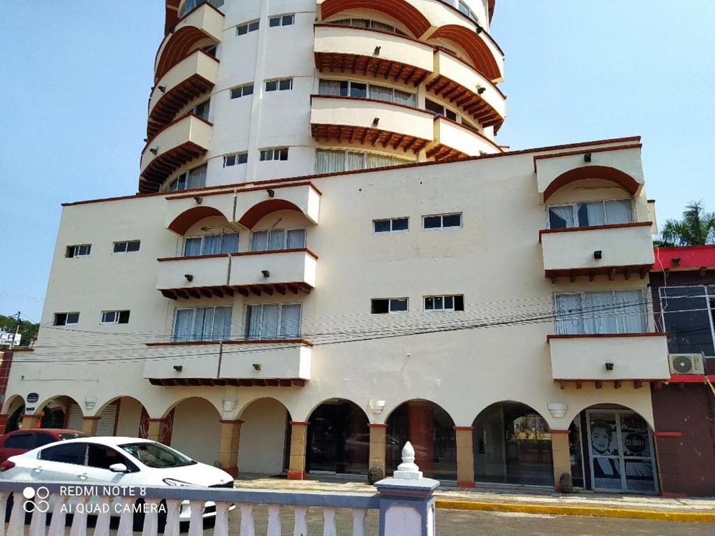 un edificio con un coche blanco aparcado delante de él en Gran Santiago Plaza, en Santiago Tuxtla