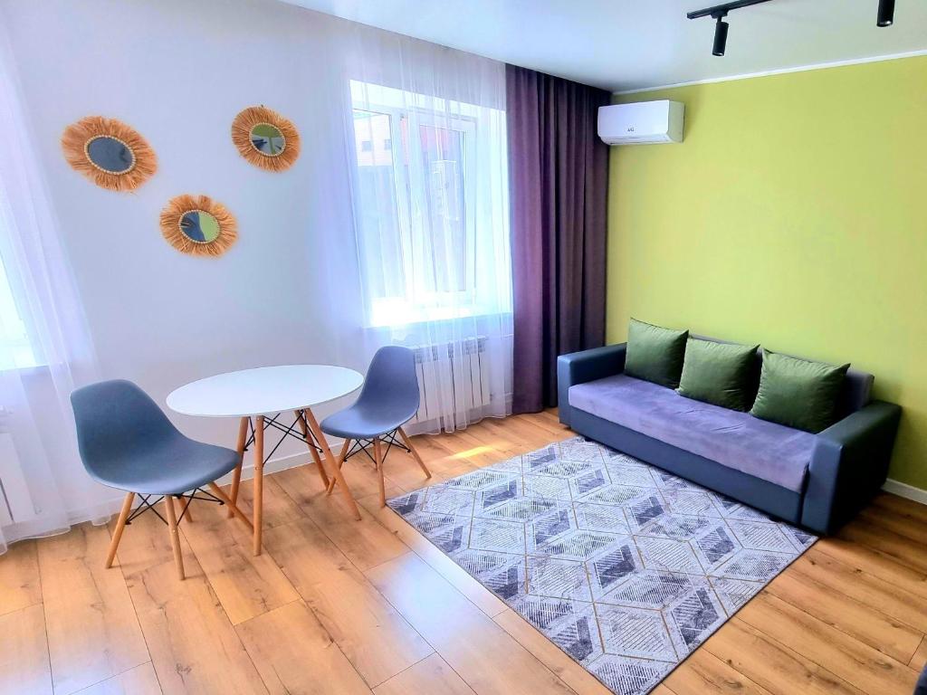 - un salon avec un canapé, une table et des chaises dans l'établissement Jenis III, à Kökşetaw