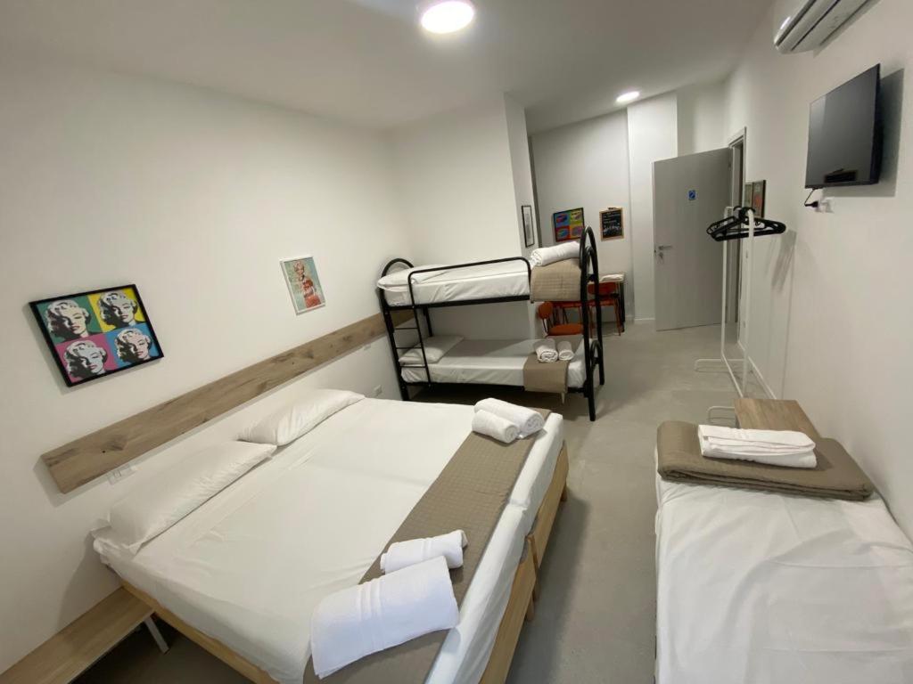 um quarto de hospital com duas camas e uma televisão em San Dionigi 11 Studio Apartments em Milão