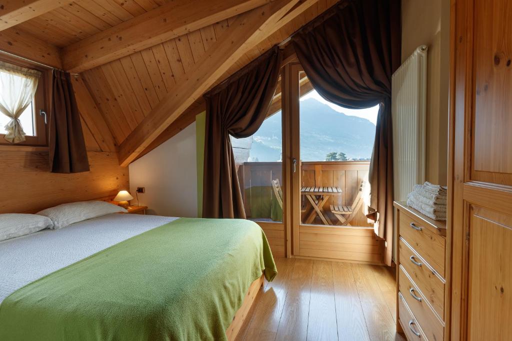 um quarto com uma cama e uma grande janela em Casa Giulia em Bormio