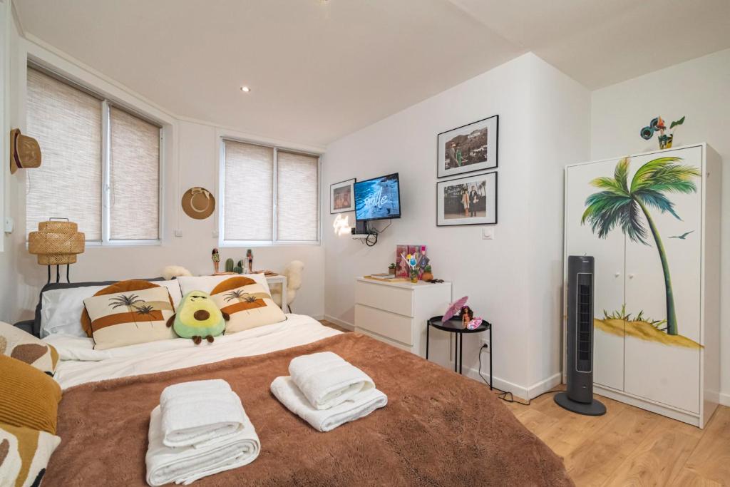 une chambre avec un grand lit avec des serviettes dessus dans l'établissement ExploreReims- Hollywood glamour proche gare/centre, à Reims