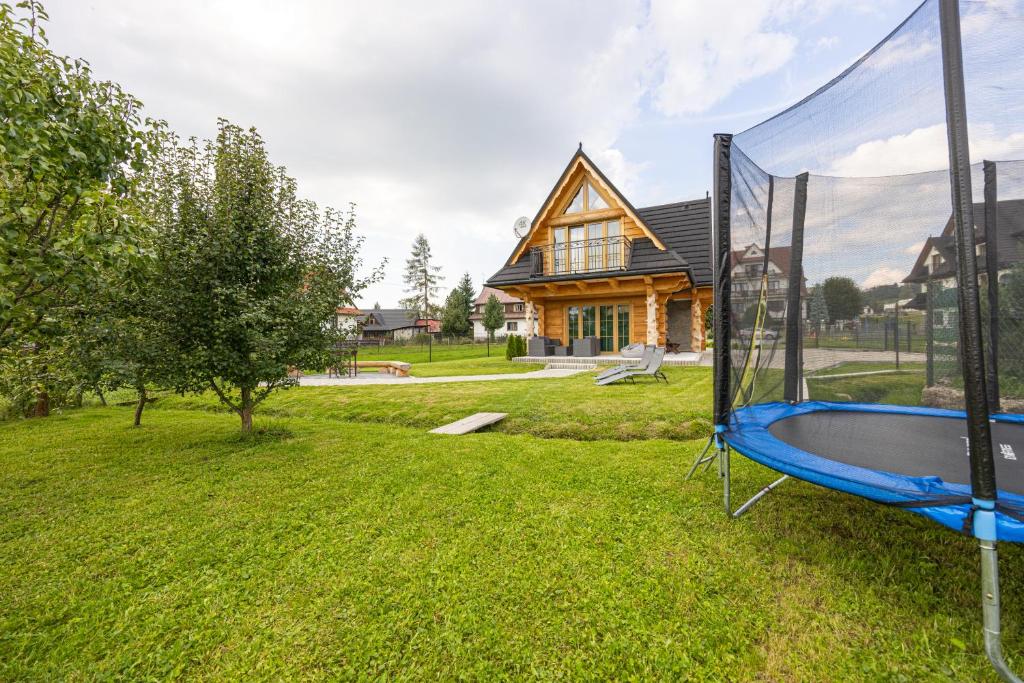 a backyard with a trampoline in front of a house at Bajka Chateau in Czarna Góra