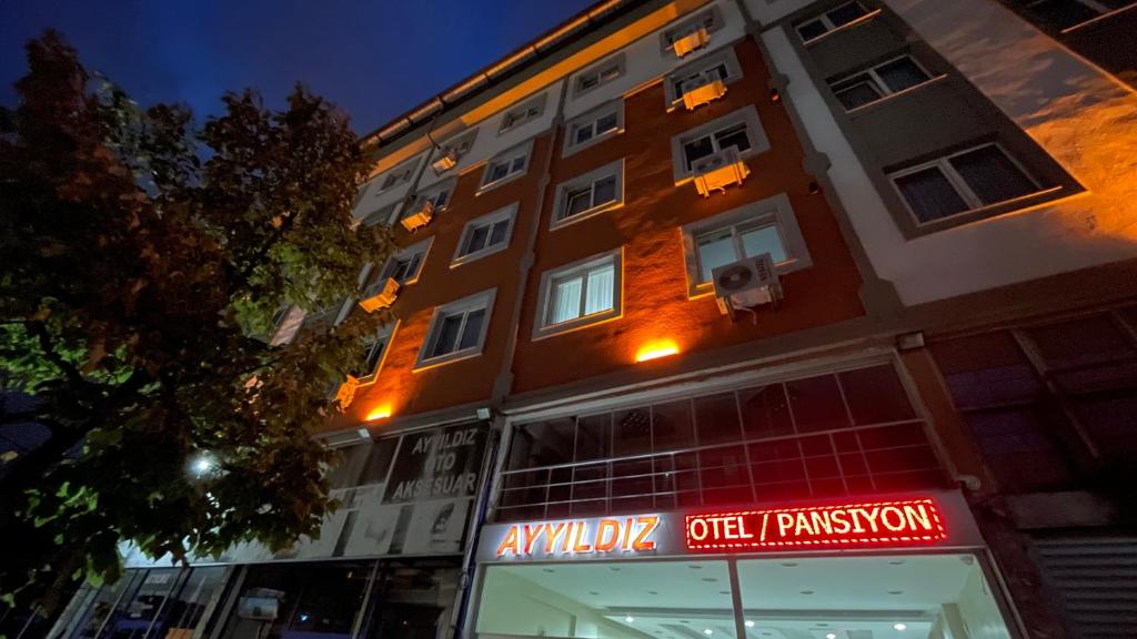 un edificio con una señal delante de él en Ayyıldız Pansiyon Apart en Degirmen