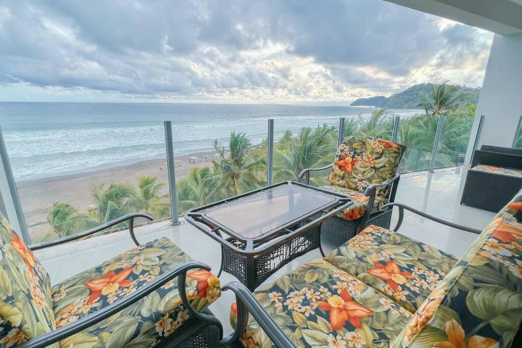 ハコにあるLuxury beach condo, stunning sunset & ocean viewのバルコニー(椅子、テーブル付)、