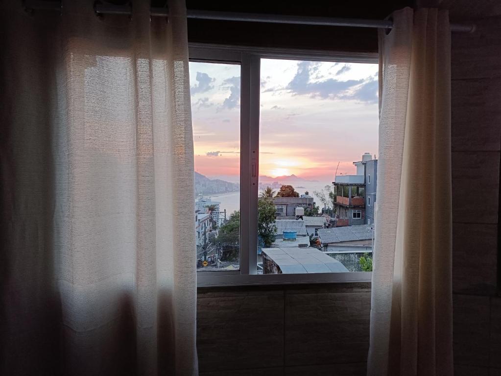 uma janela com vista para o pôr-do-sol em Apêzinho Vidigal - RJ no Rio de Janeiro