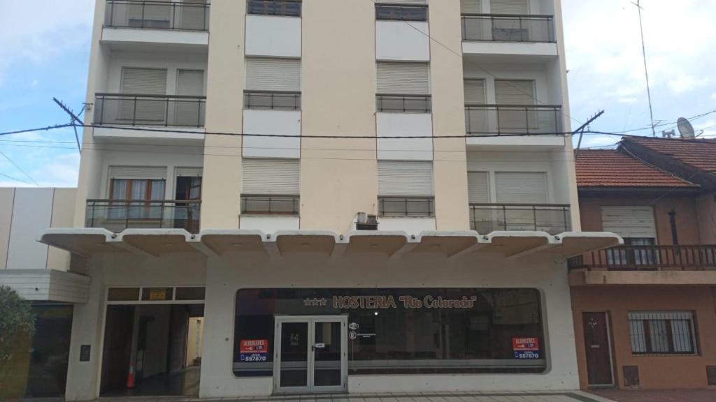 un edificio blanco alto con una tienda delante en Nueva Hostería Rio Colorado Necochea en Necochea