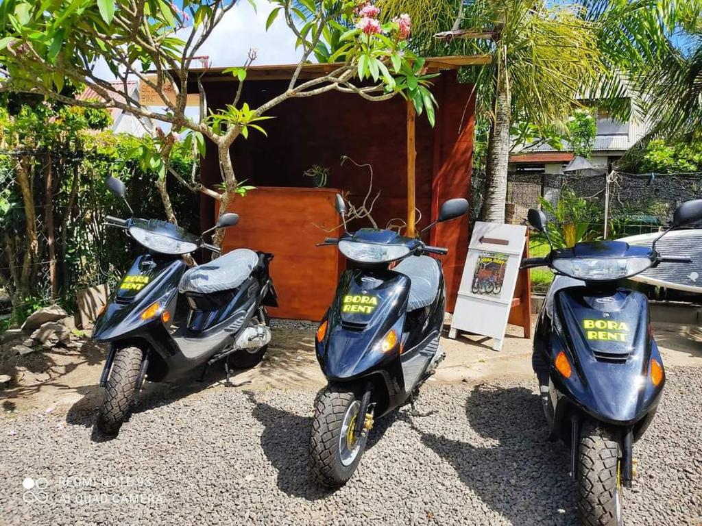 dos scooters estacionados frente a una casa en Bora Rent lodge en Bora Bora