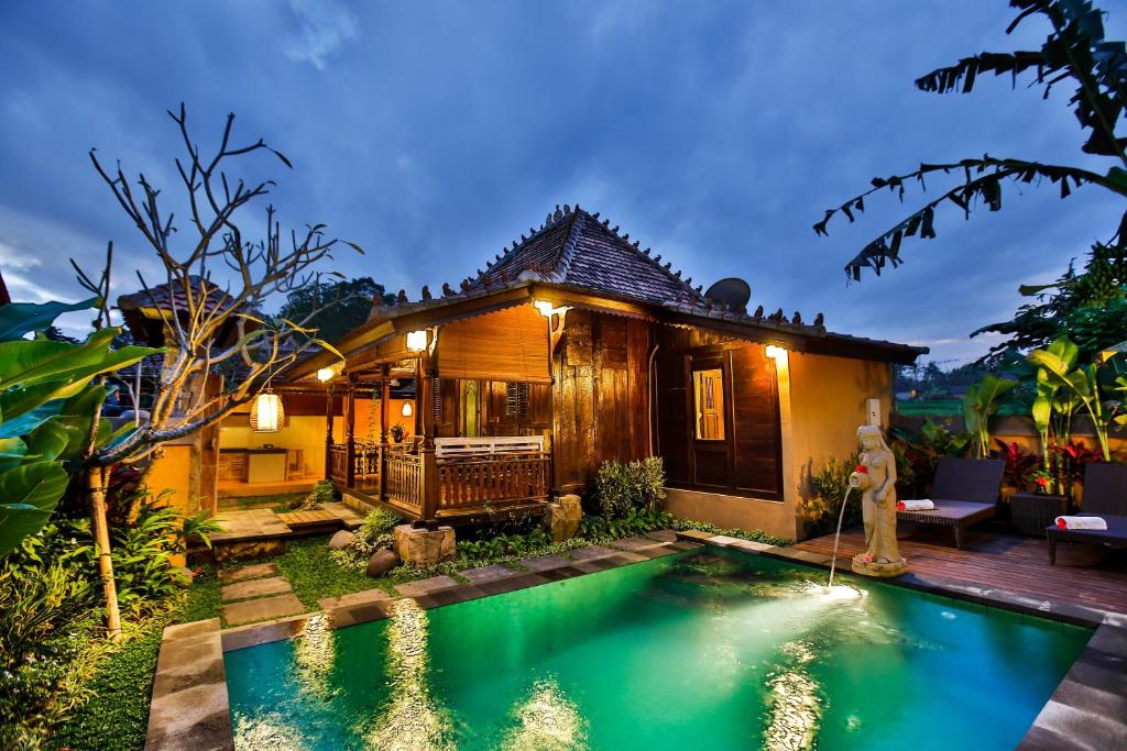 une villa avec une piscine en face d'une maison dans l'établissement Villa Nini, à Ubud