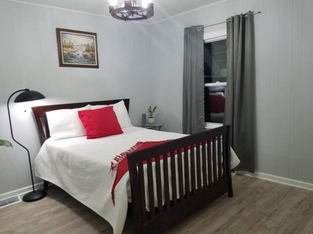 1 dormitorio con 1 cama con almohada roja en LH Guest house, en Lake in the Hills