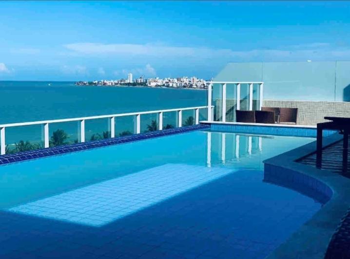 a swimming pool with a view of the water at Lindo Flat completo em Intermares 404 in Cabedelo