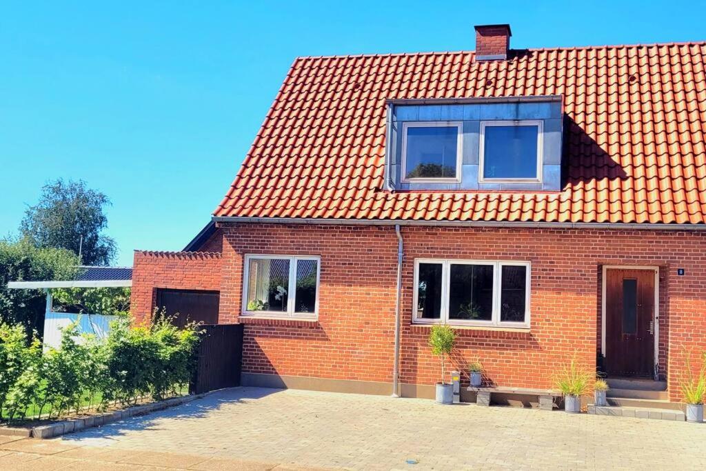 a brick house with a red roof and windows at Skønt hus - tæt på Givskud Zoo og Legoland in Give