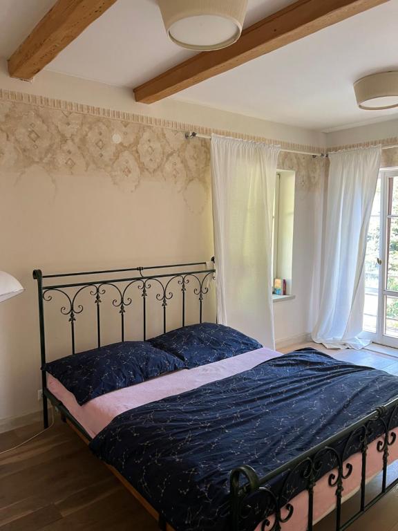 a bedroom with a bed with a blue comforter and a window at Vila Bellevue in Jablonec nad Nisou