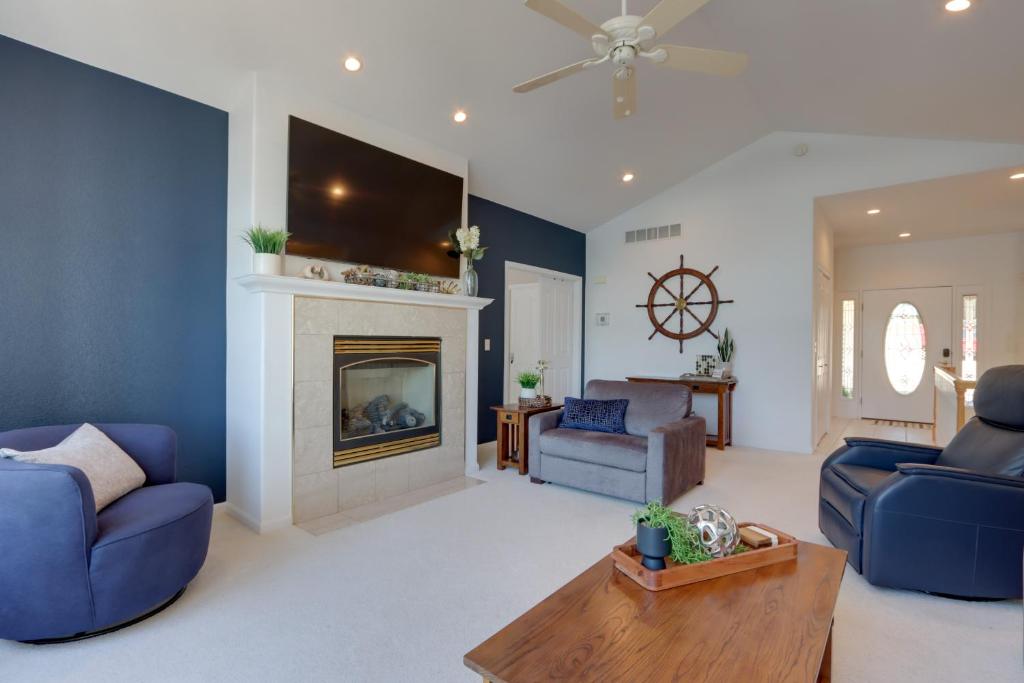 a living room with two blue chairs and a fireplace at Private Dock and 4 Decks Lake Ozark Retreat! in Gravois Mills