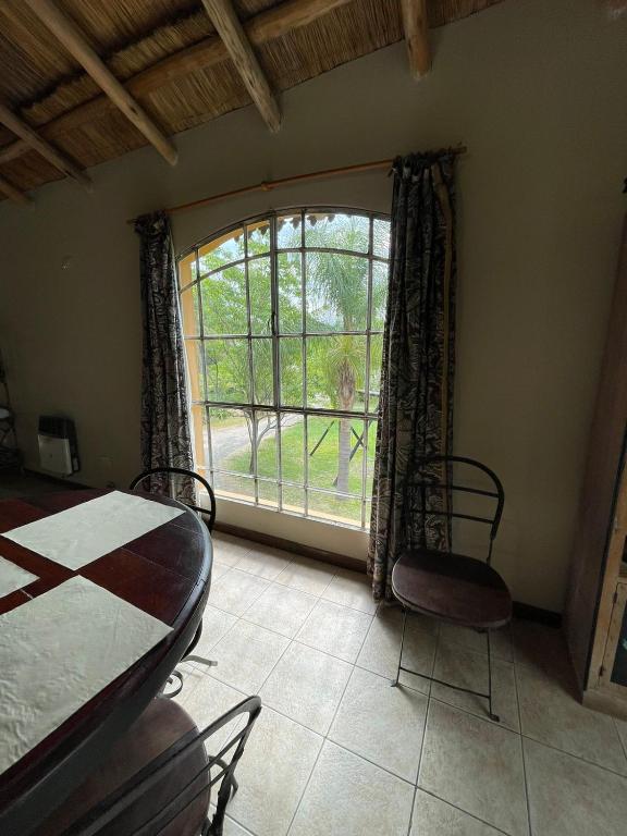 a room with a table and chairs and a large window at don isidro cabaña alta in La Paz
