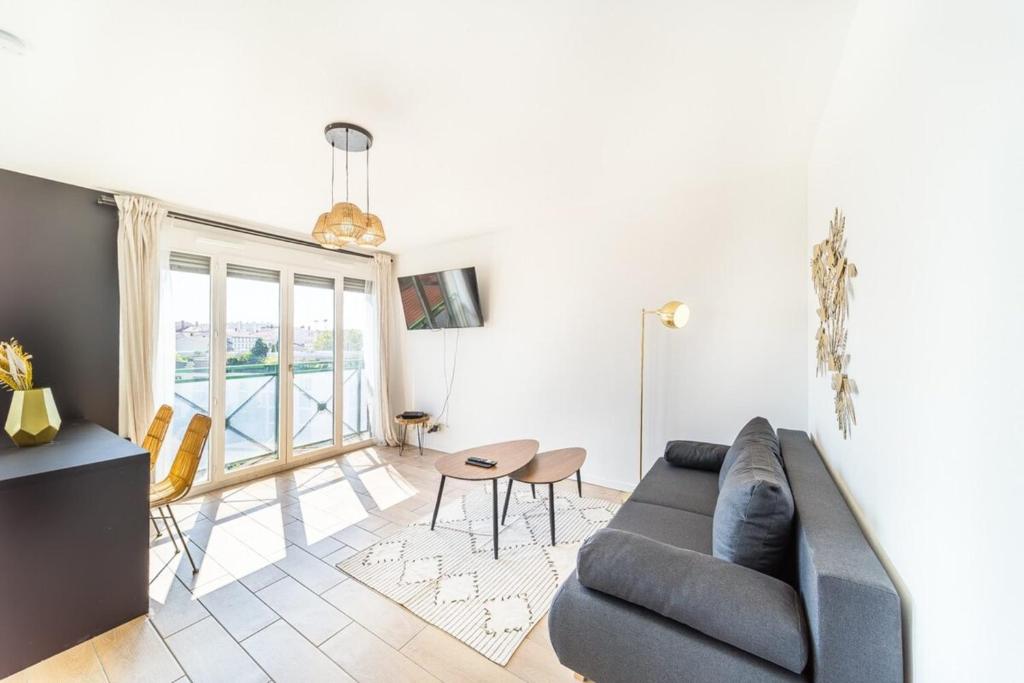 un salon avec un canapé et une table dans l'établissement Le Cocon Margnolles - Caluire Croix Rousse, à Caluire-et-Cuire