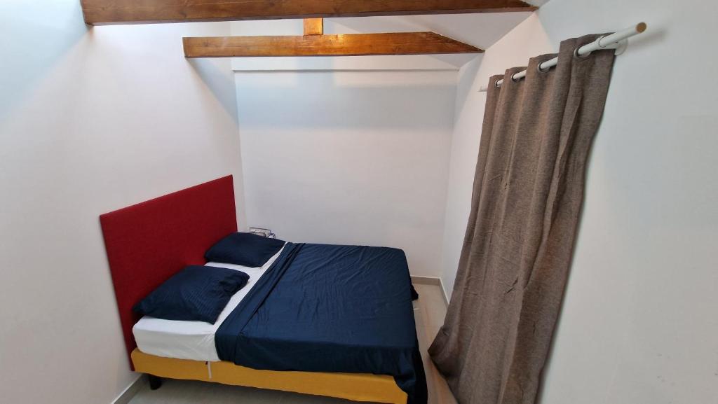 een klein bed in een kamer met een gordijn bij Le 23 in Colombes