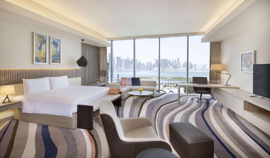 دبل تري باي هيلتون في الدوحة: غرفة فندقية بسرير ونافذة كبيرة