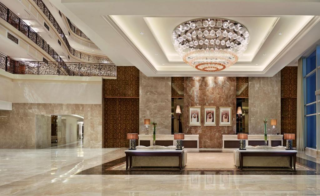a lobby with two tables and a chandelier at Waldorf Astoria Dubai Palm Jumeirah in Dubai