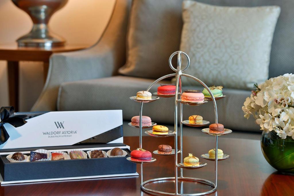 a display of pastries on a table in a living room at Waldorf Astoria Dubai Palm Jumeirah in Dubai