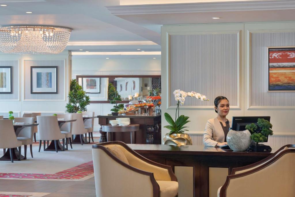 a woman sitting at a table in a restaurant at Waldorf Astoria Dubai Palm Jumeirah in Dubai