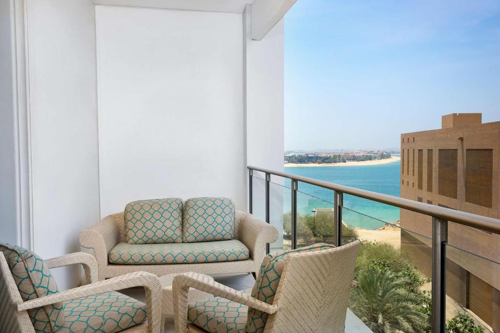 a balcony with chairs and a view of the ocean at Waldorf Astoria Dubai Palm Jumeirah in Dubai