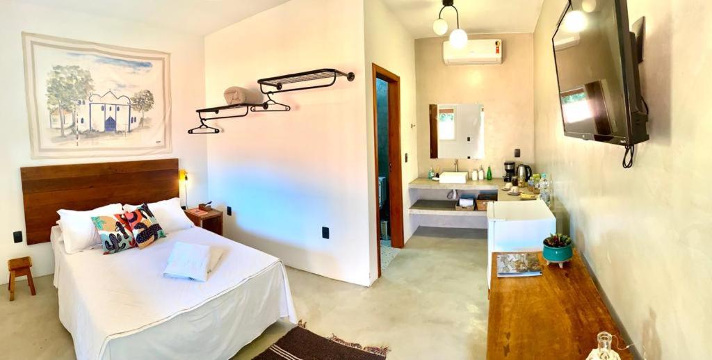 een slaapkamer met een bed en een badkamer met een wastafel bij XIQUE XIQUE ITAUNAS HOSPEDARIA in Itaúnas