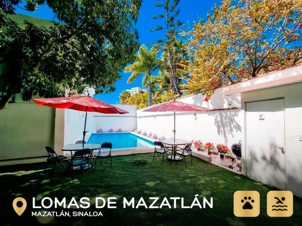 un patio avec des tables et des parasols et une piscine dans l'établissement Hostal La Casa de Madera, à Mazatlán