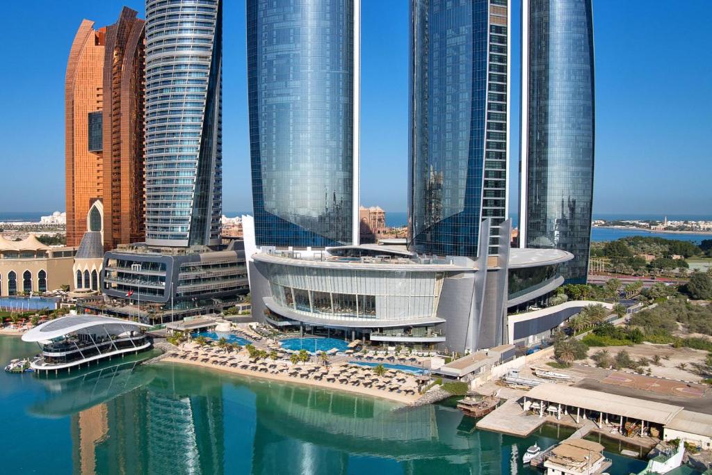 un gruppo di edifici alti in una città con acqua di Conrad Abu Dhabi Etihad Towers a Abu Dhabi