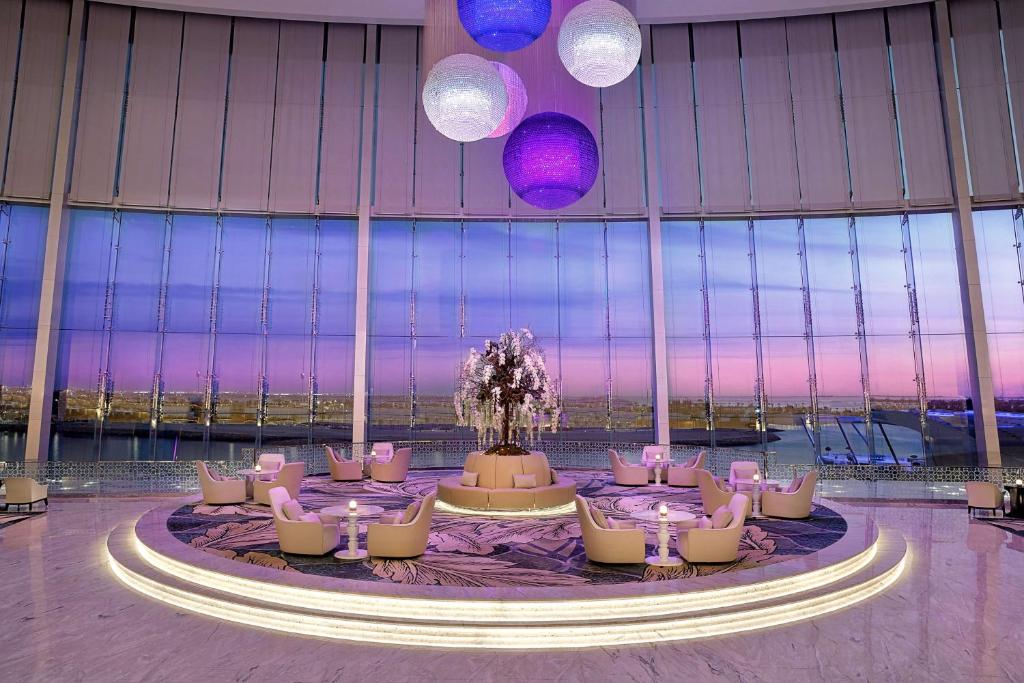 a large room with tables and chairs in a building at Conrad Abu Dhabi Etihad Towers in Abu Dhabi