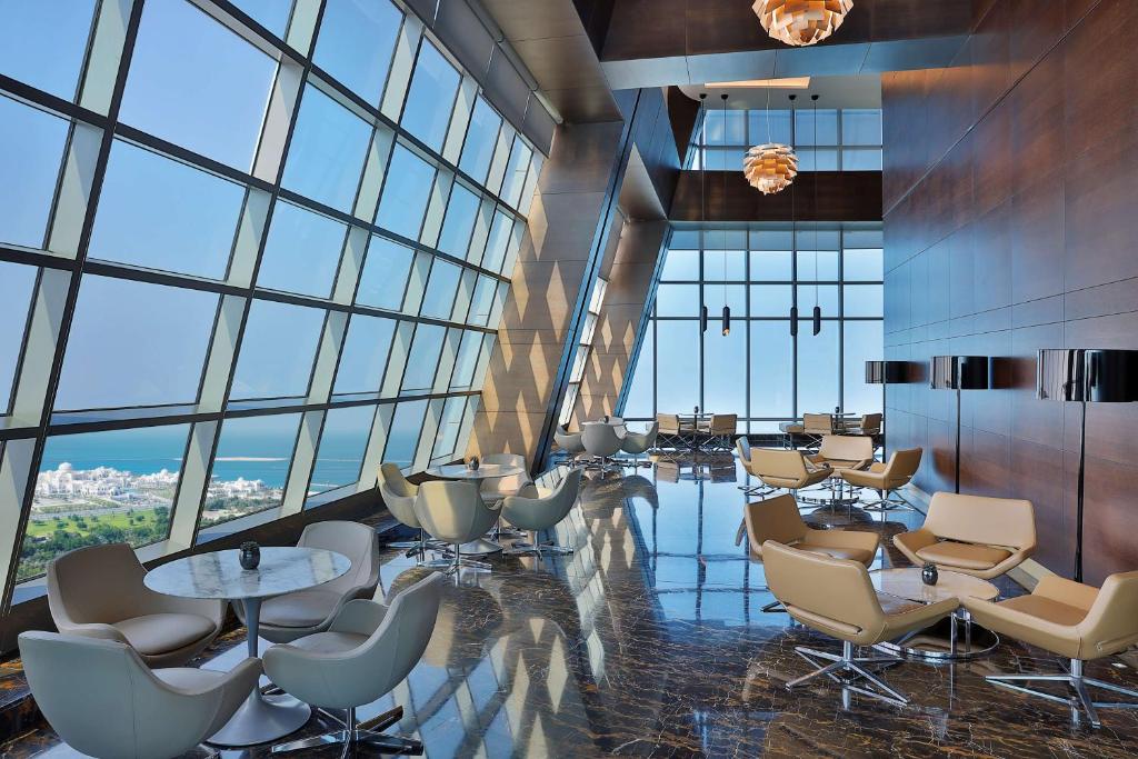 a conference room with chairs and tables and windows at Conrad Abu Dhabi Etihad Towers in Abu Dhabi