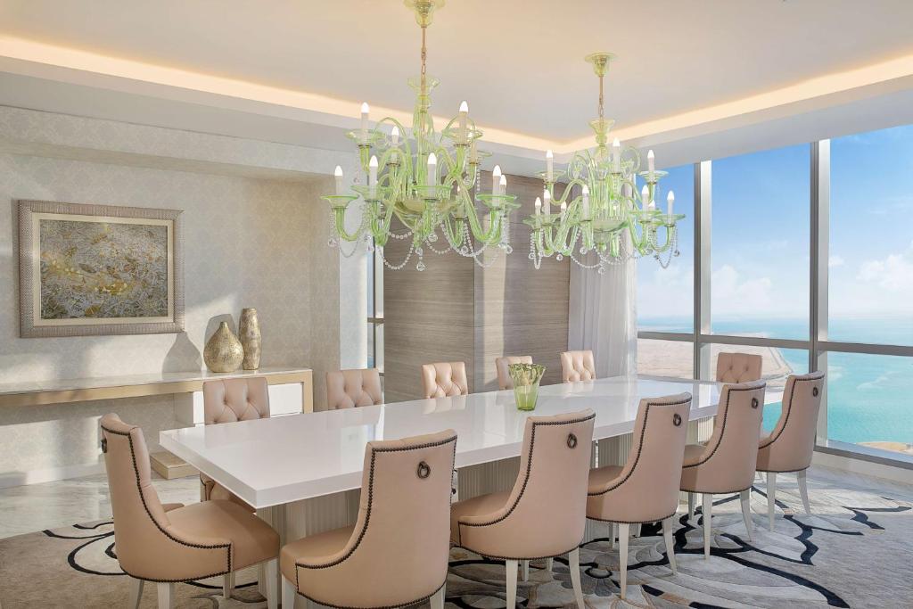 a dining room with a white table and chairs at Conrad Abu Dhabi Etihad Towers in Abu Dhabi