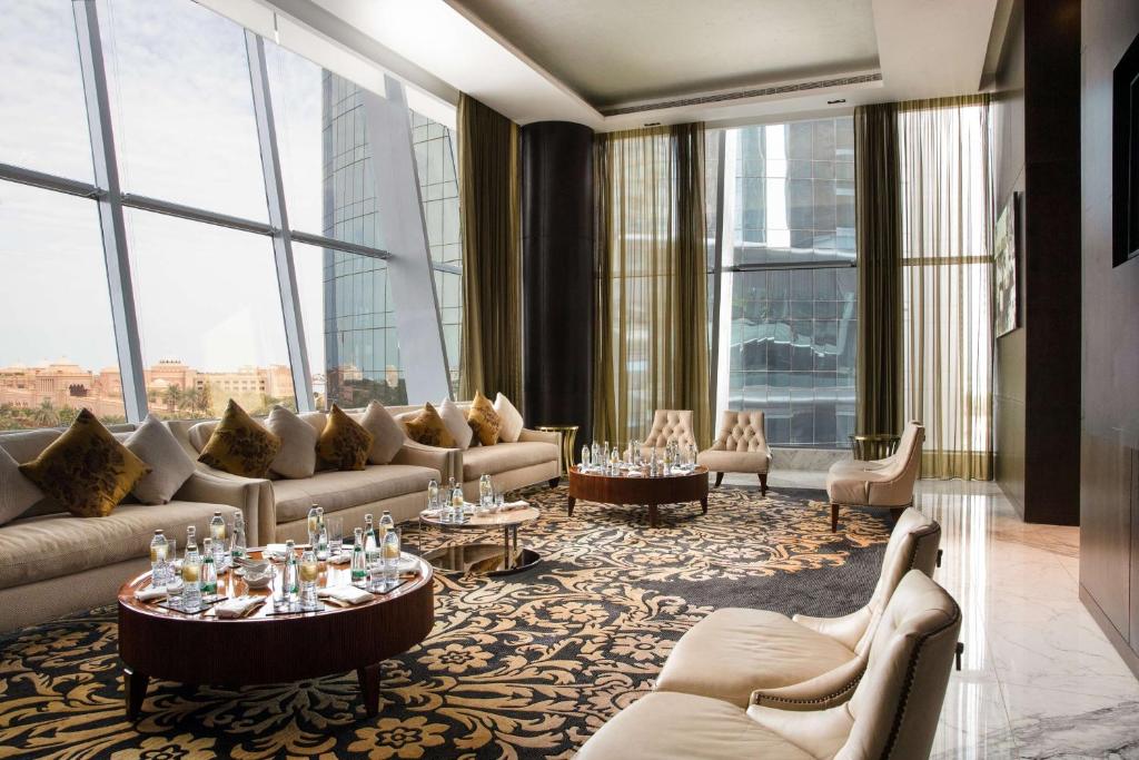 a living room with couches and tables and windows at Conrad Abu Dhabi Etihad Towers in Abu Dhabi