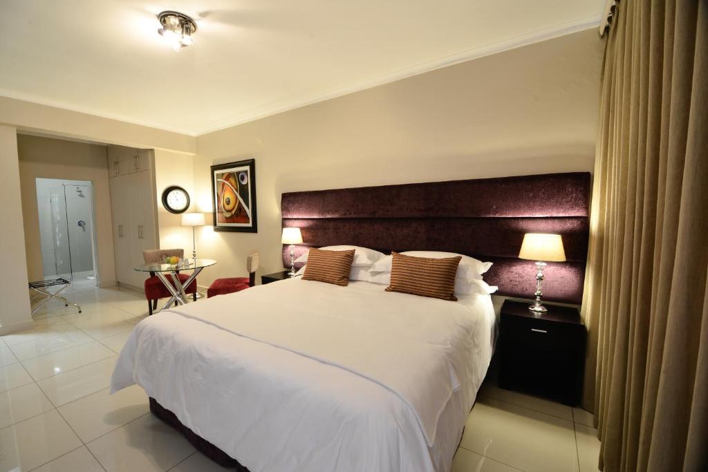 a bedroom with a large bed with a wooden headboard at Vredenburg Boutique Lodge in Vredenburg