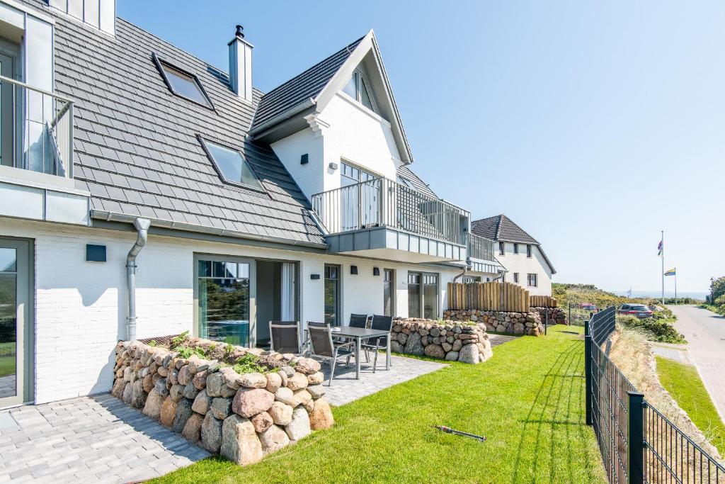 a house with a patio and a fence at Haus Dünenweg Whg 2 in Hörnum