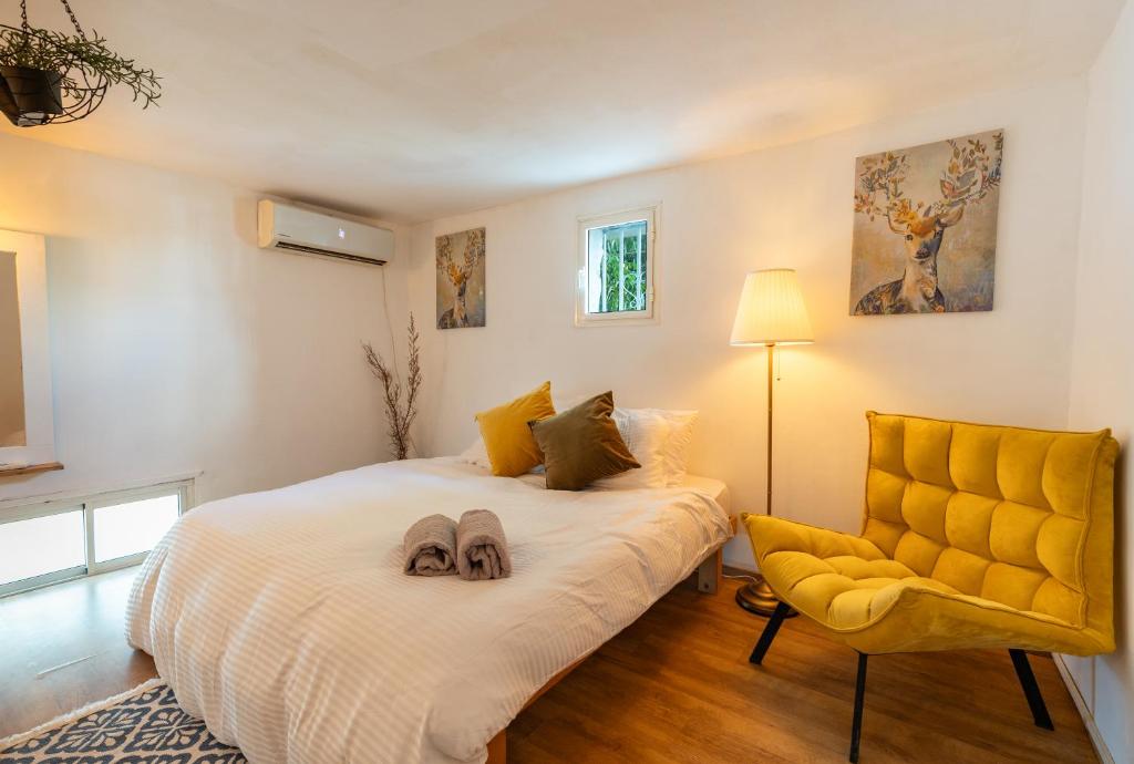 ein Schlafzimmer mit einem Bett und einem gelben Stuhl in der Unterkunft Perfect Apartment Jaffa Beach in Tel Aviv