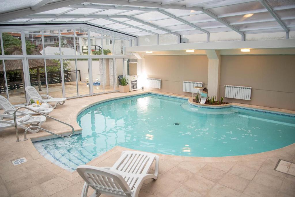 a large swimming pool with chairs at Fonte Arcada in Villa Gesell