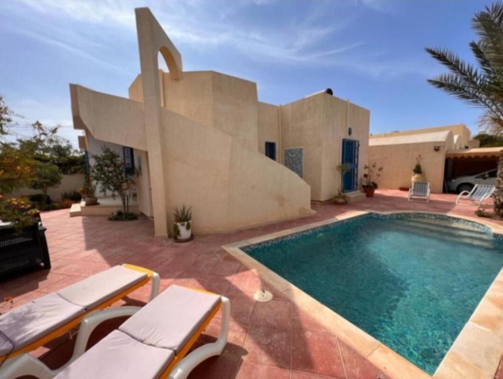 une villa avec une piscine en face d'une maison dans l'établissement Villa Elena, à Midoun
