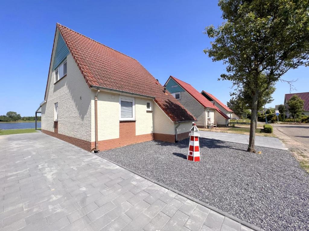 une maison avec un toit rouge et un cône de circulation rouge et blanc dans l'établissement Sonnenschein, à Stevensweert