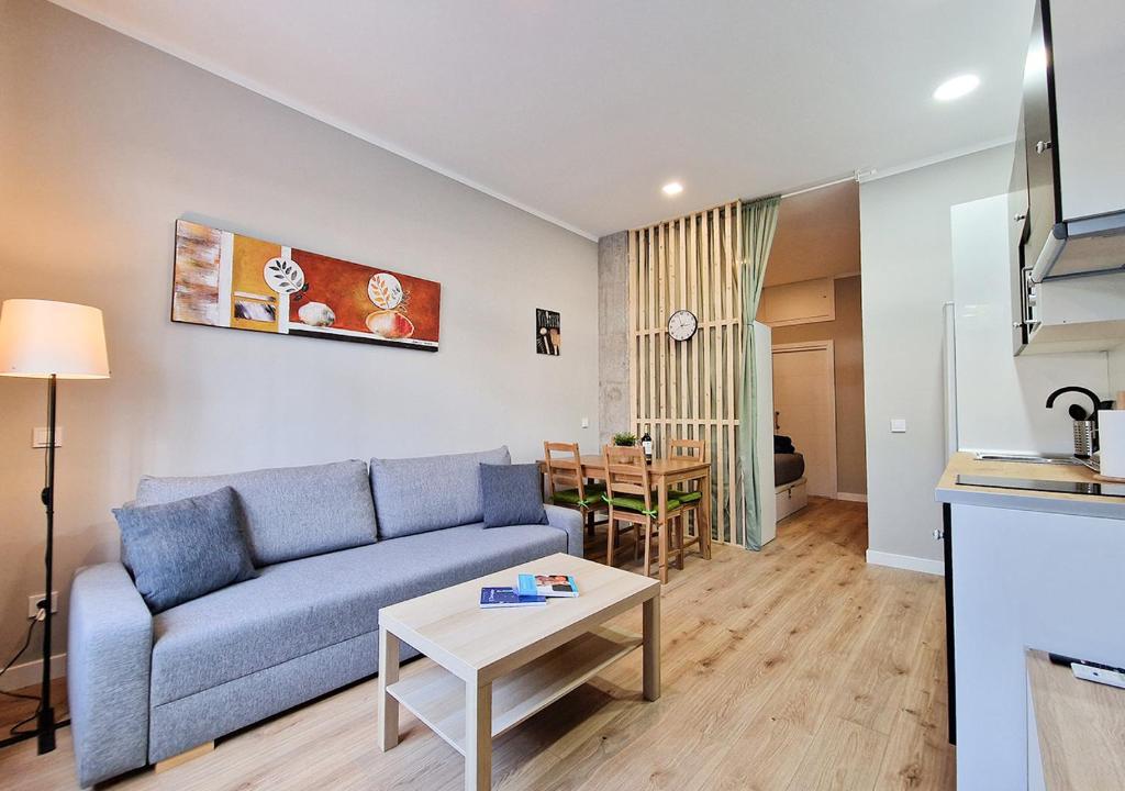 - un salon avec un canapé bleu et une table dans l'établissement Manzanares 'Madrid Rio', à Madrid