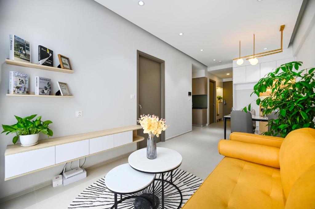 uma sala de estar com um sofá amarelo e uma mesa em Căn hộ Westgate- 2N House em Ho Chi Minh