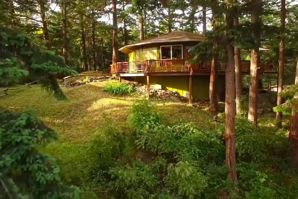 a house in the woods with a wrap around deck at The Island Treehouse in Eastsound
