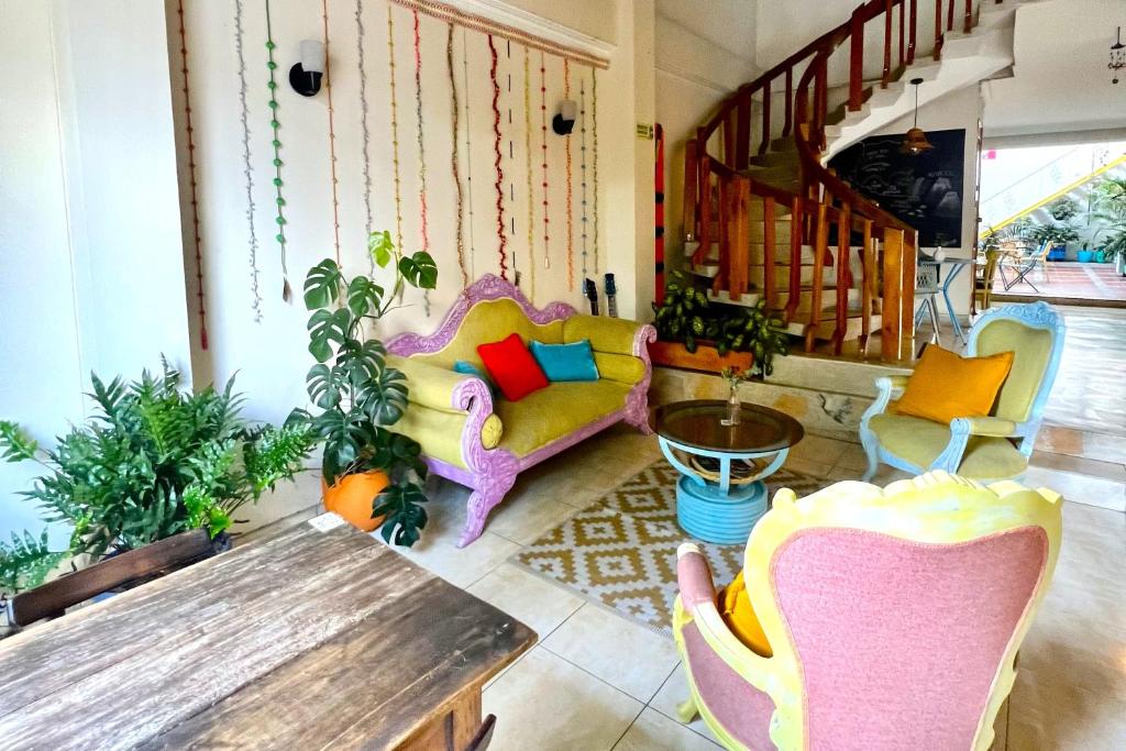 uma sala de estar com um sofá, cadeiras e uma mesa em Casa Azul Boutique Hostel em Pereira