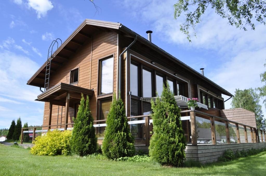 une grande maison en bois avec des fenêtres en verre dans l'établissement Kiurunrinne Villas, à Imatra