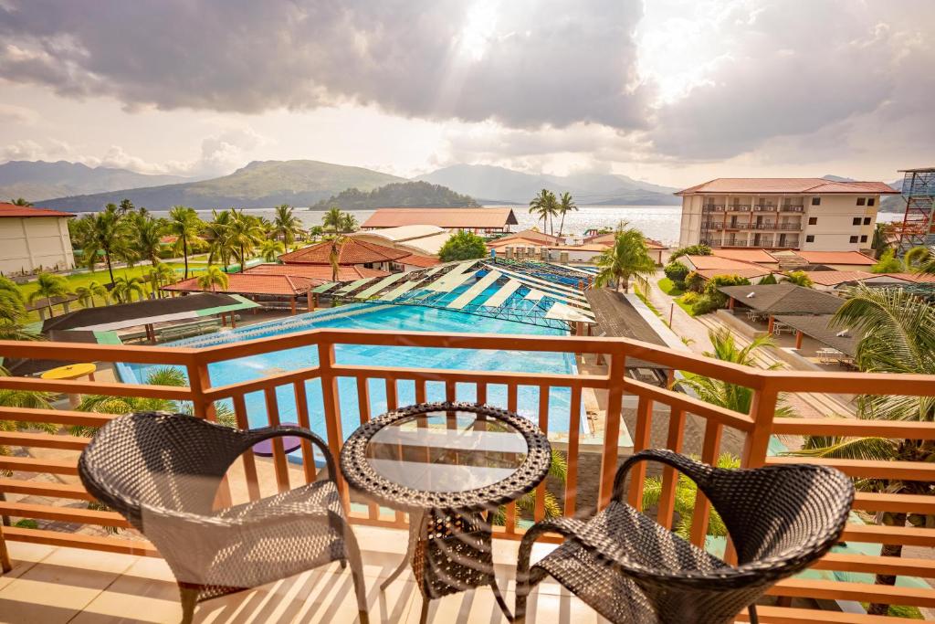 un balcón con 2 sillas y una piscina en Whiterock Beach Hotel and Waterpark en Subic