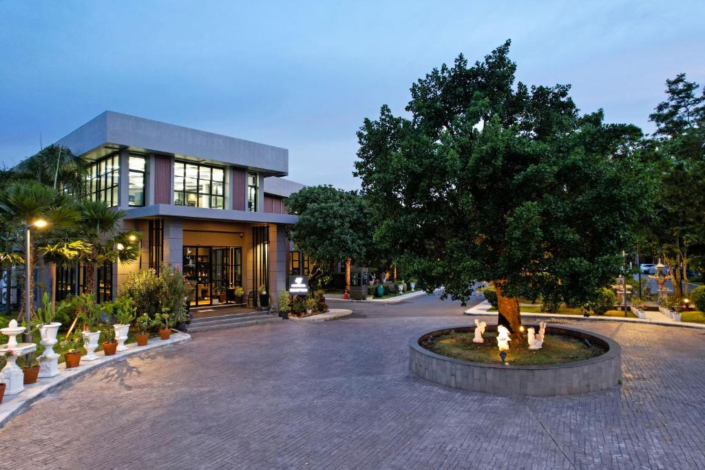 a building with a tree in the middle of a street at Raweewan Residence hotel in Bangkok