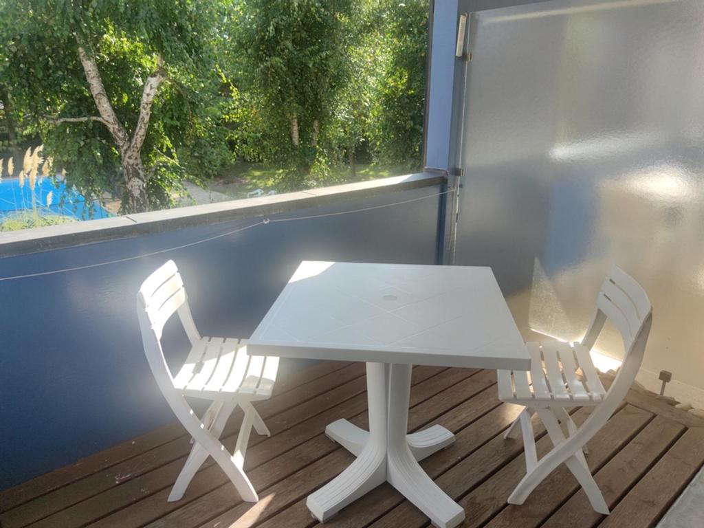 una mesa blanca y 2 sillas frente a una ventana en Appartement Arzon, 2 pièces, 4 personnes - FR-1-639-32, en Arzon