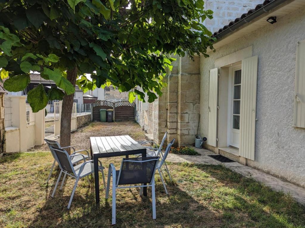 stół i krzesła na dziedzińcu obok budynku w obiekcie Maison charentaise rénovée avec jardin privé, proche d'Angoulême et activités en bord de Charente - FR-1-653-208 w mieście Vindelle