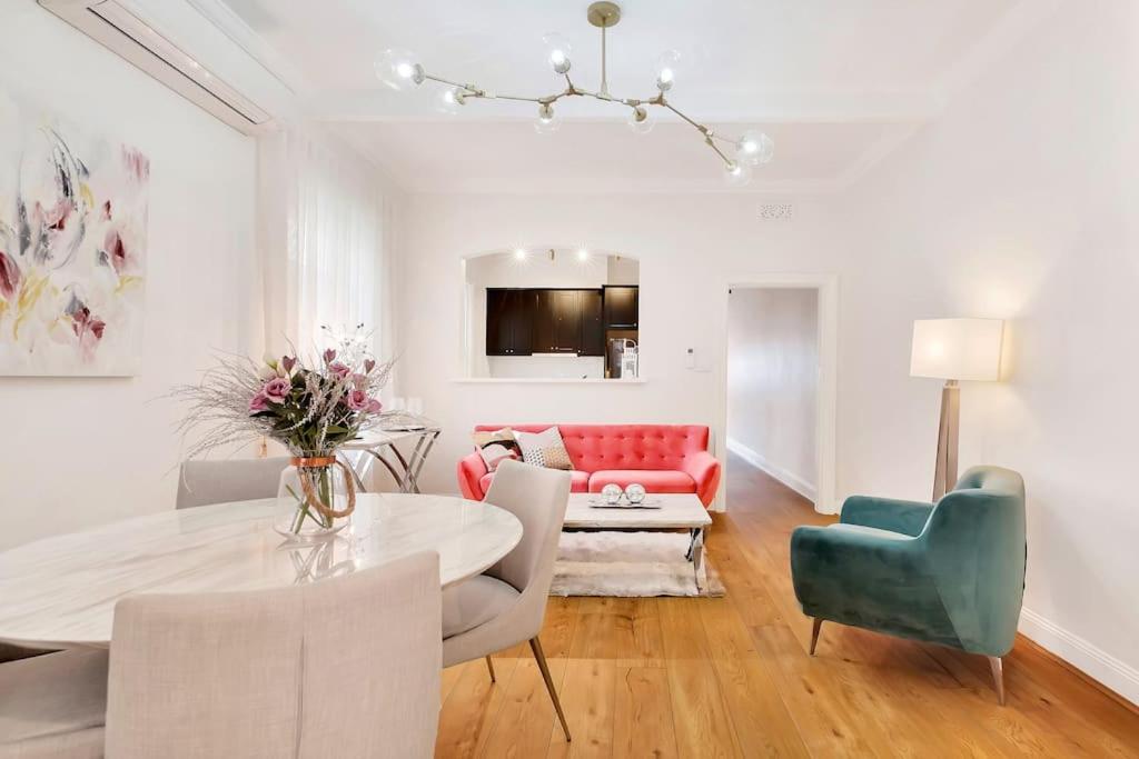 sala de estar con mesa y sofá rojo en Sydney CBD Waterview apartment56 en Sídney