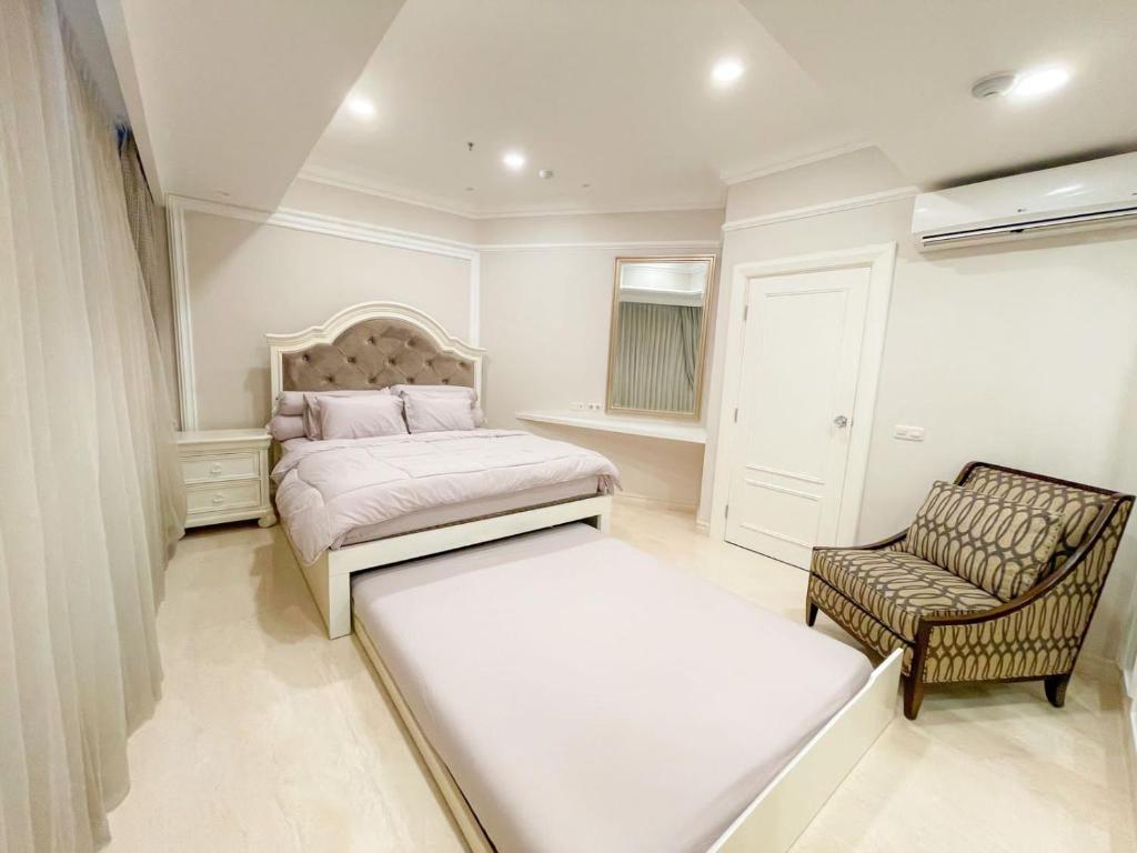 um quarto com uma cama e uma cadeira em Elegance penthouse em Surabaya
