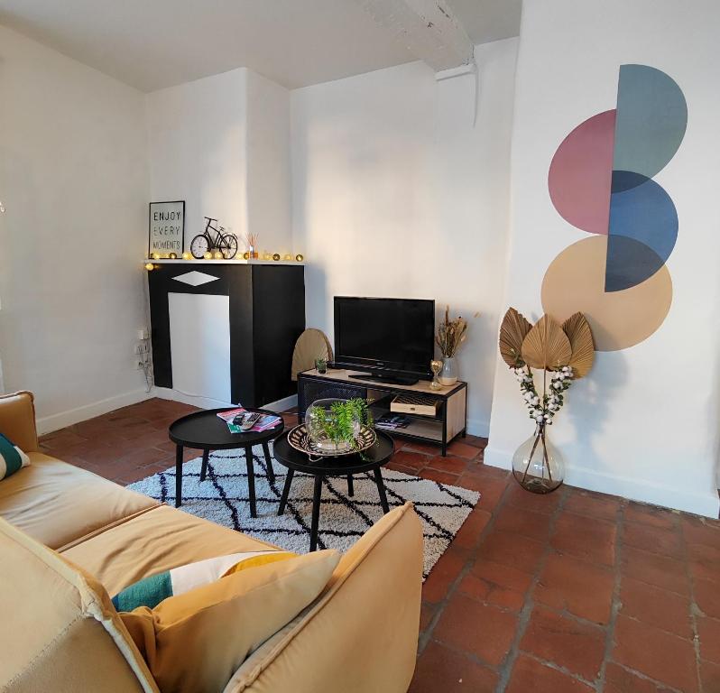 a living room with a couch and a tv at Numéro 6 - Place Nationale - Wifi et Fibre in Montauban